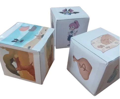 Trois cubes en papier illustrés, des lanceurs d'histoires, avec des dessins d'animaux et de personnages de BD de Junior Éditions.